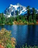 Laguna azul y montaña con cumbre Nevada