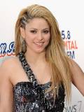Shakira delante de un Cartel